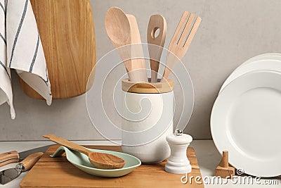 Set of different kitchen utensils and plates on white near gray wall Stock Photo