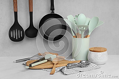 Set of different kitchen utensils on white near gray wall Stock Photo