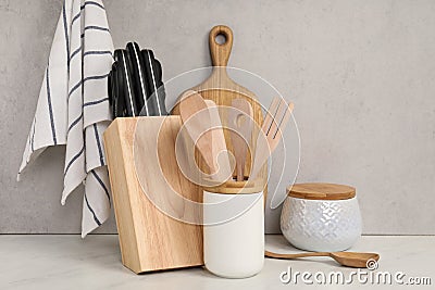 Set of different kitchen utensils on white near gray wall Stock Photo