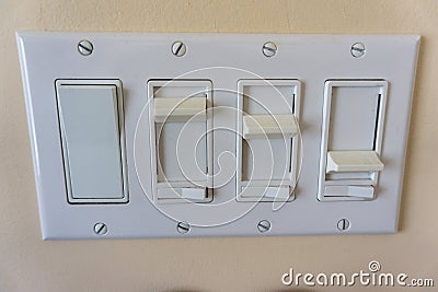Set of dimmer light switches fixed on a plate on a wall Stock Photo