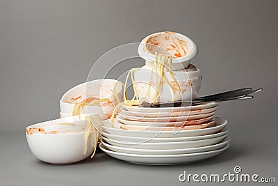 Set of dirty dishes with spaghetti leftovers on grey Stock Photo