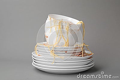 Set of dirty dishes with spaghetti leftovers on grey Stock Photo