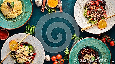 A set of dishes. Pasta with parmesan cheese and vegetable salad and blue cheese. Top view. Stock Photo