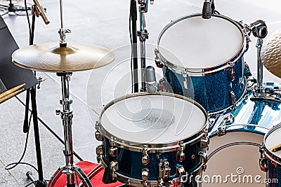 Set of drums, cymbals and microphones on pavement background Stock Photo