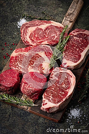 Set of Fresh raw marbled beef steaks on a wooden Board: tenderloin, Striploin, ribeye Stock Photo