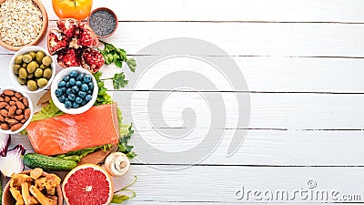 A set of healthy food. Fish, nuts, protein, berries, vegetables and fruits. On a white background. Top view. Stock Photo