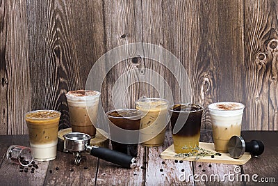 Set of iced coffee drinks arranging on dark brown wooden floor and background decorated by coffee beans group handle and tamper Stock Photo