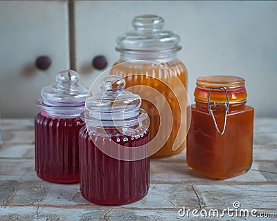 A set of jars with homemade jam on a room table, red currant and apple jam Stock Photo