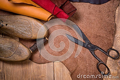 Set of leather craft tools on wooden background. Workplace for shoemaker. Stock Photo