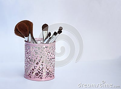 Set of makeup brushes in a pink iron glass Stock Photo