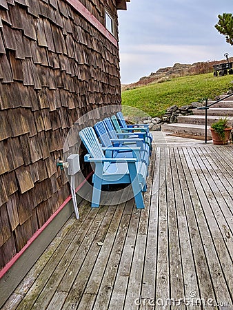 Set of blue chairs on a beachfront property patio on a clear day Stock Photo