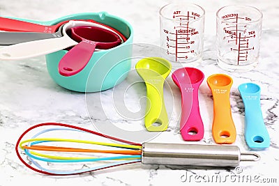 Set of measuring cups, measuring spoons, measuring glasses and silicone whisk use in cooking lay on marble tabletop Stock Photo