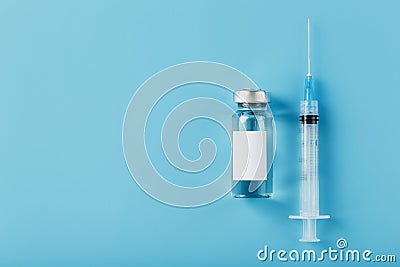 Ampoule with a vaccine and a syringe for viruses and diseases on a blue background Stock Photo