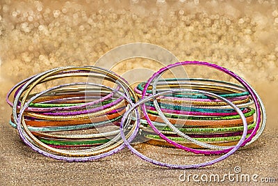 Set of multiple multi-colored bracelets on a golden background Stock Photo