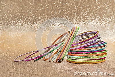 Set of multiple multi-colored bracelets on a golden background Stock Photo