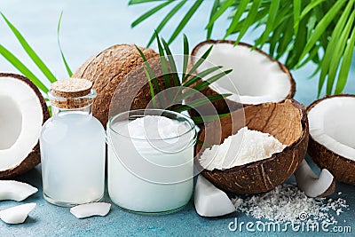 Set of natural coconut products for spa treatment, cosmetic or food ingredients decorated palm leaves.Coconut oil, water, shavings Stock Photo