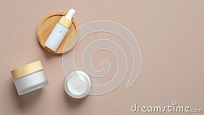 Set of natural cosmetic products on beige background. Flat lay serum dropper bottle and moisturizer cream jars. Organic beauty Stock Photo