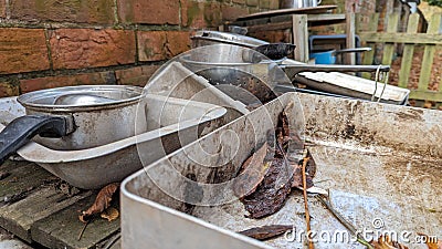 A set of old baking trays and pots in a childs outdoor mud kitchen Stock Photo