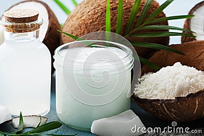 Set of organic coconut products for spa, cosmetic or food ingredients decorated palm leaves. Natural oil, water and shavings. Stock Photo