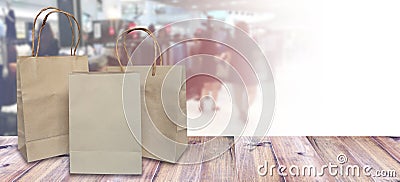 brown shopping bags on wood table over blurry sale shop at department store background. Stock Photo