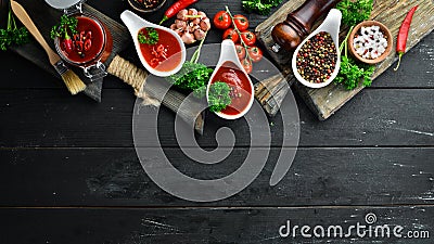 Set of red sauces on a wooden background. Ketchup, barbecue sauce, tomato sauce. Top view. Stock Photo