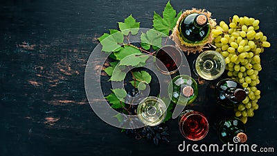 Set of red and white wine in bottles and glasses. Grape. On a black wooden background. Free space for text. Stock Photo