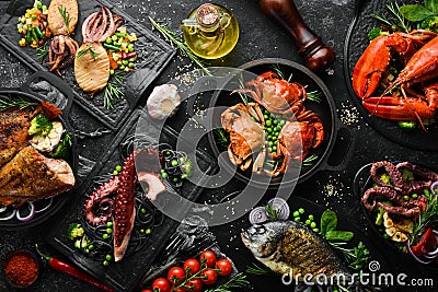 Set of seafood dishes. Fish, squid, octopus on a black stone background. Top view. Stock Photo