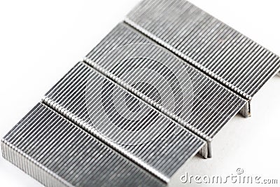 A set of silver metal staples on white, top view, closeup. Office accessories and common workplace items and supplies, office Stock Photo