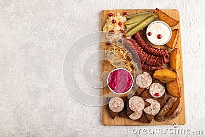 Set of snacks: sausages, toast, sauerkraut, marinated onion and cucumber, baked potato. Top view, copy space Stock Photo