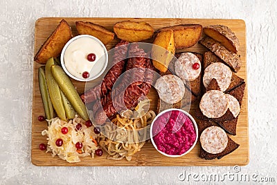 Set of snacks: sausages, toast, sauerkraut, marinated onion and cucumber, baked potato. Top view Stock Photo