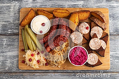 Set of snacks: sausages, toast, sauerkraut, marinated onion and cucumber, baked potato. Top view Stock Photo