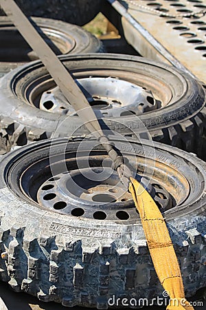 A set of spare wheels for a rally car, lying on the trailer and wrapped with a belt Editorial Stock Photo