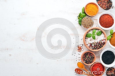 A set of Spices and herbs on a white wooden table. Basil, pepper, saffron, spices. Indian traditional cuisine. Stock Photo