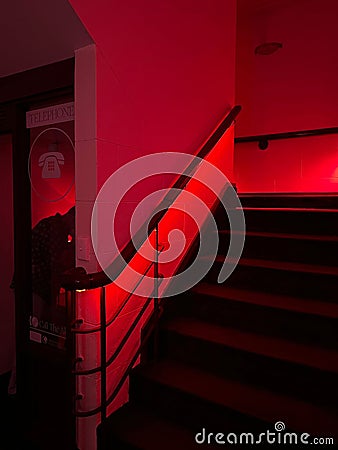 a set of stairs with red lighting in the dark room Stock Photo
