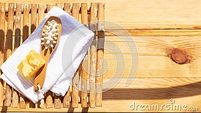 Set for a steam bath. Towel, soap and body brush. View from above. Bright sunshine and shadows Stock Photo