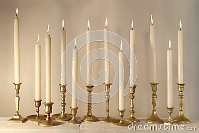 Burning candles in retro candlesticks indoor Stock Photo
