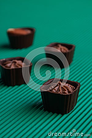 Set of sweet delicious praline brown candies on green background. Stock Photo