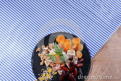 Set of sweet snacks. A plate with turkish delight and fruits on a fabric background. Nutritious desserts. Copy space. Stock Photo