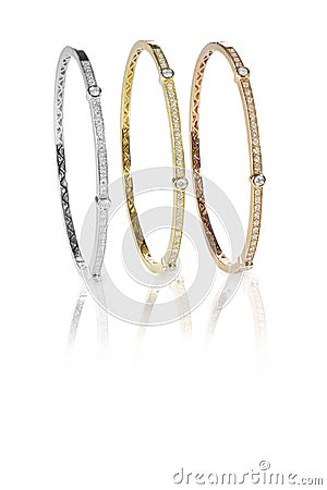 Set of three colored gold diamond bangle bracelets standing upright Stock Photo