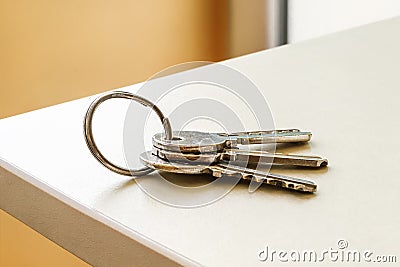 Set of three house keys on the ring on table in a room. Bunch of apartment keys. To forget keys at home. Stock Photo