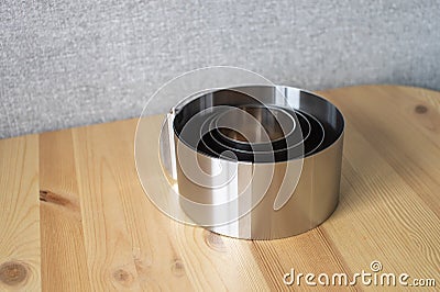 A set of tools for a confectioner. Round molds for baking cakes of different sizes on a wooden table Stock Photo