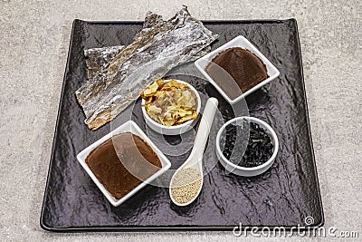 Set of traditional Japanese ingredient for cooking basic dashi broth. Algae kombu and wakame, miso paste, katsuobushi and dry Stock Photo