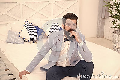 Set up for hard day. Man formal suit sit on bed. Businessman before difficult working day. Thoughtful groom before Stock Photo