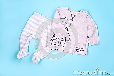 Set of warm baby clothes with bodysuits for boy on blue background. Collection of cute baby clothes. Gift for the birth of a boy Stock Photo