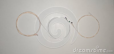 Set of wound steel and bronze acoustic electric guitar strings rolled up and formed on isolated and white background Stock Photo