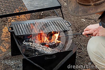 Setting the campfire in a portable foladble firepit for a camp cooking Stock Photo