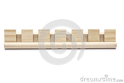 Seven blank scrabble tiles on a wooden rack Stock Photo