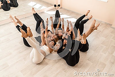 Seven happy women lie on their backs on the floor with their hea Stock Photo