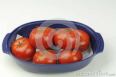 Seven Red Tomatoes in a Blue Bowl Stock Photo