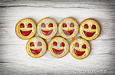 Seven round biscuits smiling faces, humorous food theme Stock Photo